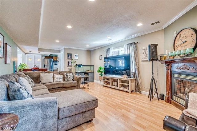 living room featuring hardwood / wood-style floors, crown molding, and a textured ceiling