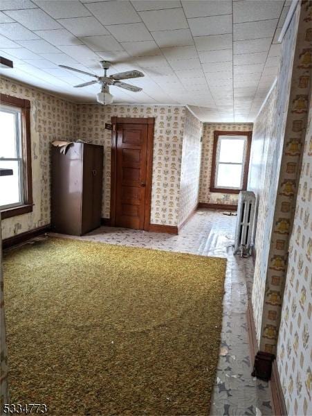 spare room featuring radiator heating unit and ceiling fan