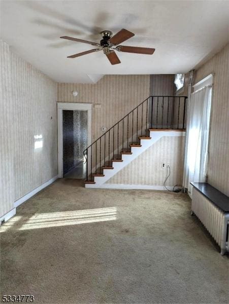 unfurnished living room featuring radiator and carpet flooring