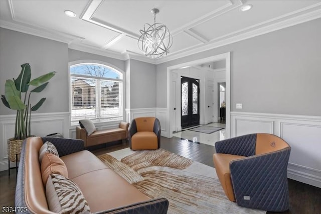 living room featuring coffered ceiling, a notable chandelier, crown molding, and dark wood-type flooring