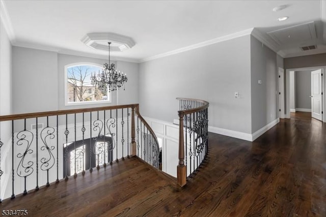 corridor featuring crown molding, dark hardwood / wood-style floors, and an inviting chandelier