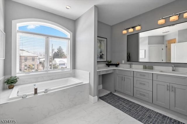 bathroom with vanity and tiled bath