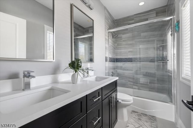 full bathroom featuring vanity, combined bath / shower with glass door, a healthy amount of sunlight, and toilet