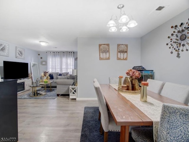 dining area featuring a notable chandelier and light wood-type flooring