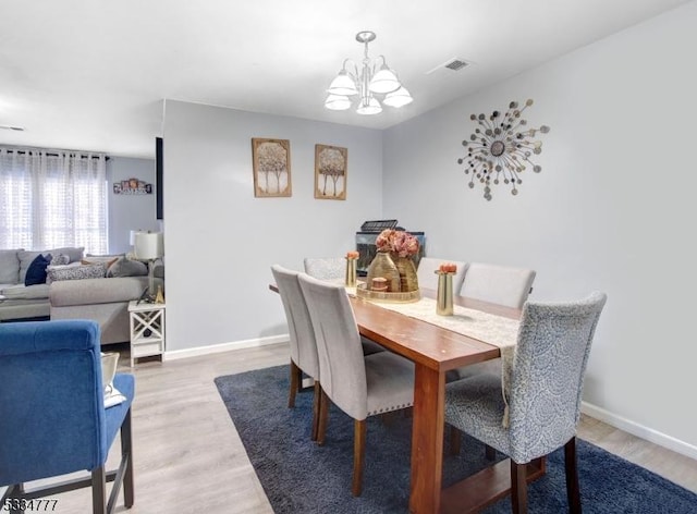 dining room featuring hardwood / wood-style flooring and an inviting chandelier