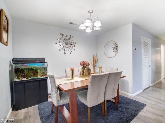 dining room featuring an inviting chandelier and light hardwood / wood-style floors