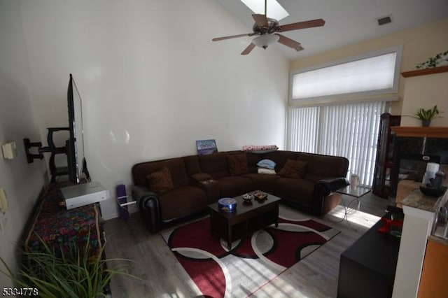 living room featuring ceiling fan, vaulted ceiling, and light hardwood / wood-style flooring