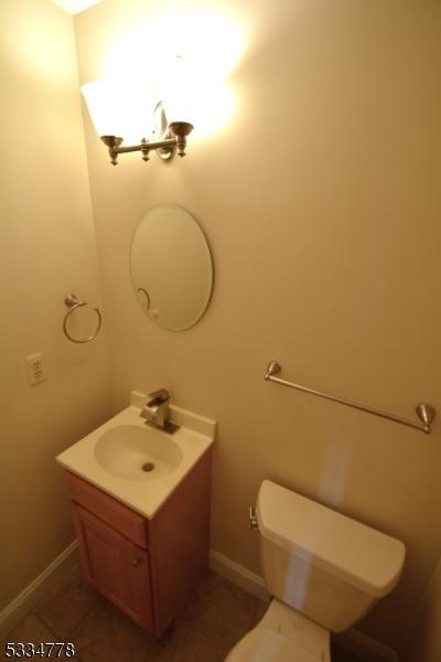 bathroom featuring vanity, tile patterned floors, and toilet