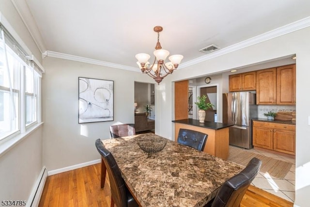 dining room featuring a baseboard radiator, ornamental molding, light hardwood / wood-style floors, and a chandelier