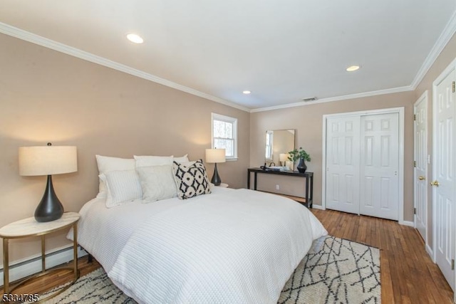 bedroom with crown molding, a baseboard radiator, a closet, and hardwood / wood-style flooring