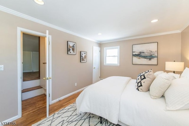 bedroom featuring crown molding and light hardwood / wood-style flooring