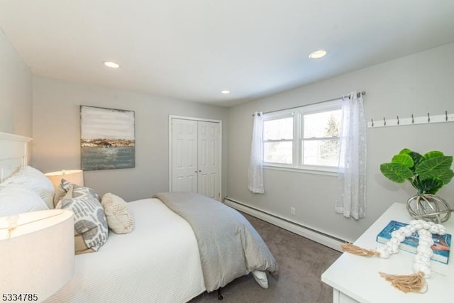 carpeted bedroom with baseboard heating and a closet