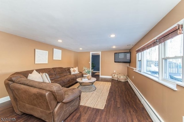 living room with a baseboard heating unit and dark hardwood / wood-style floors