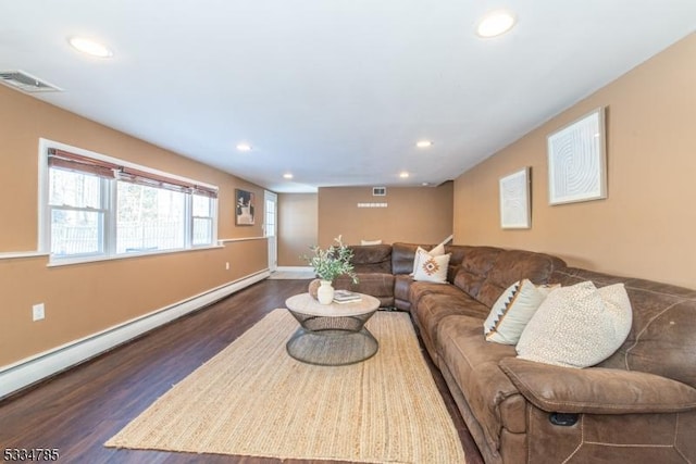 living room featuring a baseboard heating unit and dark hardwood / wood-style floors