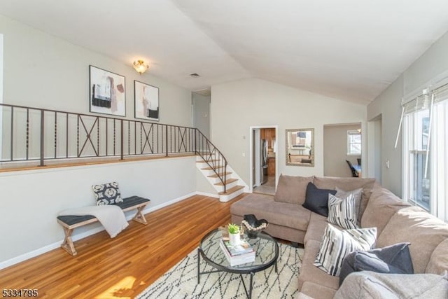 living room featuring wood-type flooring and lofted ceiling