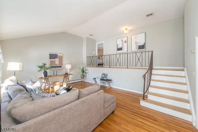 living room with hardwood / wood-style flooring and vaulted ceiling