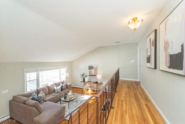 living room with lofted ceiling, light hardwood / wood-style flooring, and baseboard heating