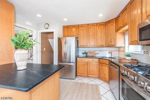 kitchen featuring light tile patterned flooring, sink, dark stone countertops, stainless steel appliances, and decorative backsplash