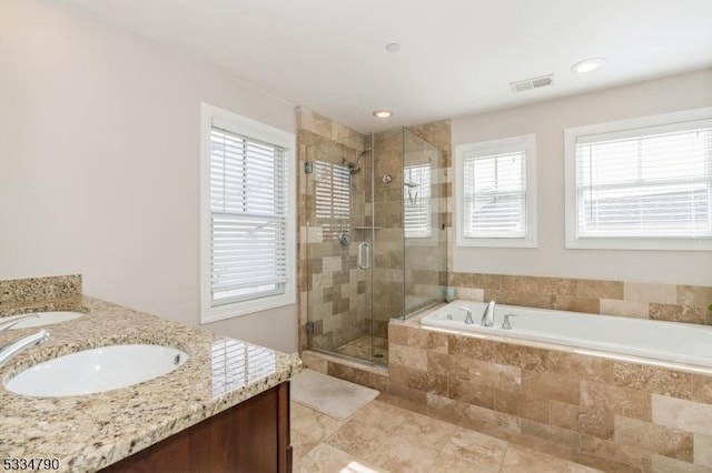 bathroom featuring double vanity, a stall shower, visible vents, a garden tub, and a sink