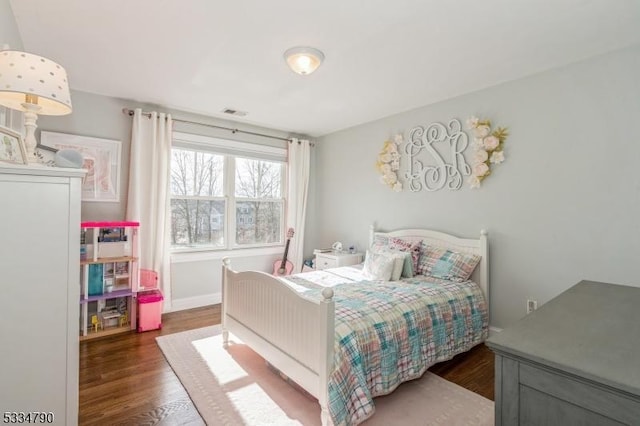 bedroom featuring baseboards and dark wood-type flooring