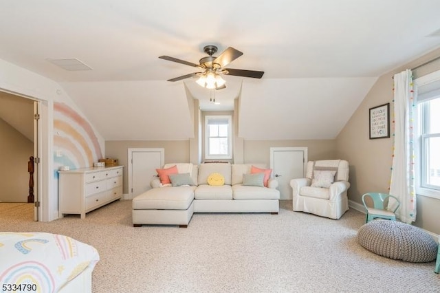 living room with baseboards, vaulted ceiling, a ceiling fan, and light colored carpet