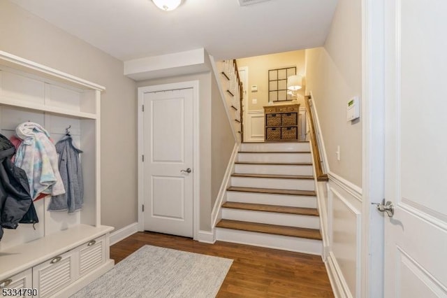 mudroom with dark wood-type flooring, visible vents, and baseboards