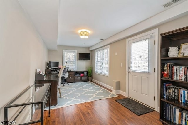 foyer with baseboards, visible vents, and wood finished floors