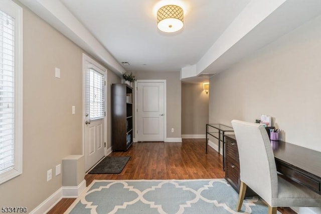 home office featuring wood finished floors, visible vents, and baseboards