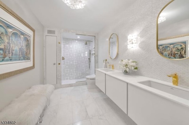 bathroom featuring vanity, tiled shower, and toilet