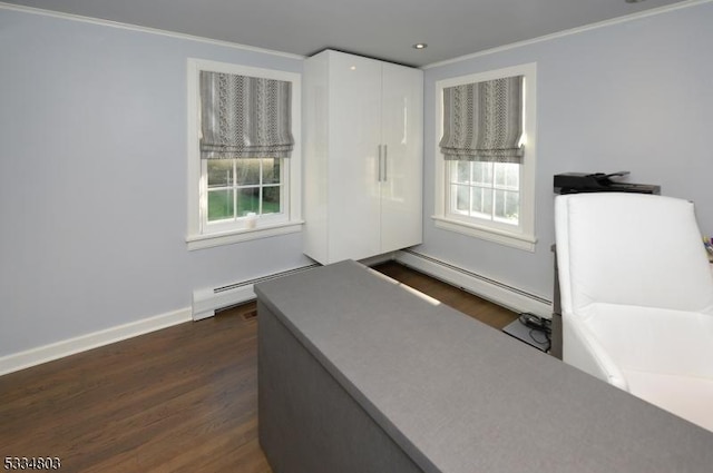 interior space with a baseboard heating unit, dark hardwood / wood-style floors, and a healthy amount of sunlight