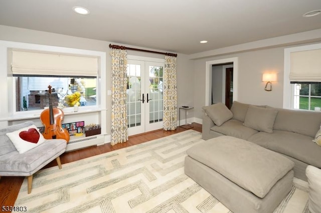 living room featuring a baseboard radiator, hardwood / wood-style floors, and french doors