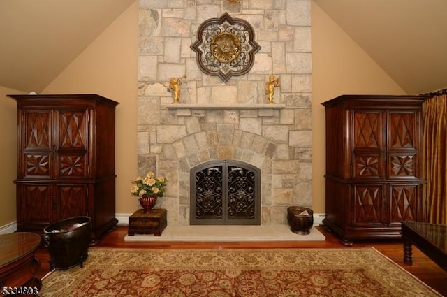 living room featuring a fireplace, hardwood / wood-style flooring, and vaulted ceiling