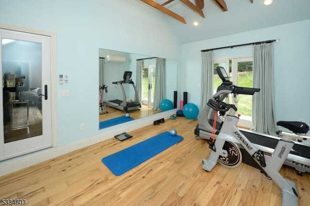 workout area featuring wood-type flooring, high vaulted ceiling, and an AC wall unit