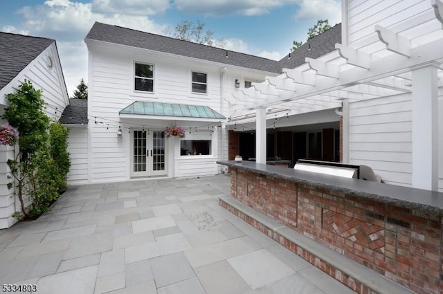 exterior space featuring french doors, a patio, a bar, and a pergola