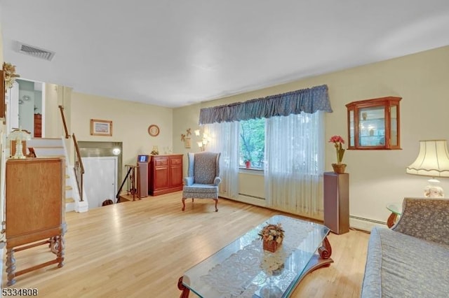 living area with a baseboard heating unit and wood finished floors