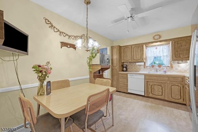 kitchen featuring white dishwasher, light countertops, ceiling fan, tasteful backsplash, and a chandelier