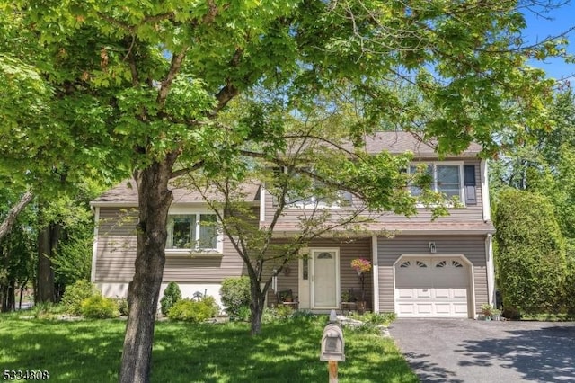 view of front of house featuring a garage, driveway, and a front yard