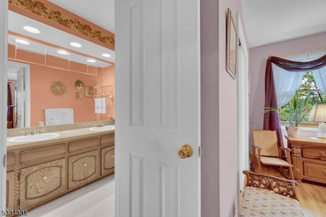bathroom featuring double vanity, wood finished floors, and recessed lighting