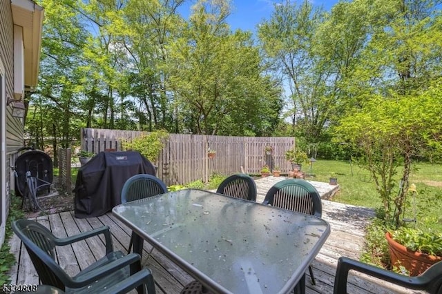 deck with outdoor dining space and area for grilling