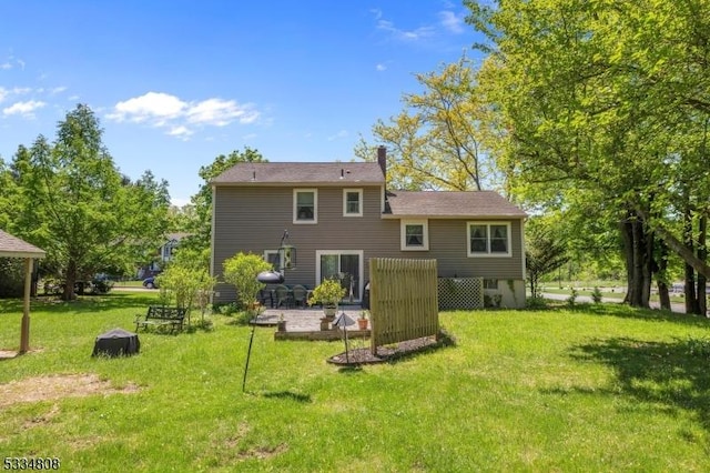 rear view of property featuring a lawn, a patio, and a chimney