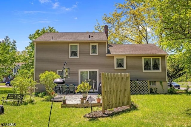 rear view of house with a patio area, a lawn, and a chimney