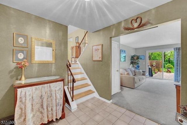 stairs with carpet flooring, tile patterned floors, and baseboards