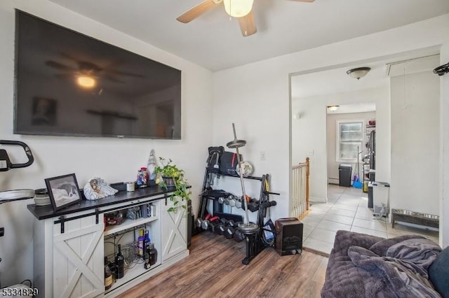 living room featuring hardwood / wood-style flooring, ceiling fan, and baseboard heating