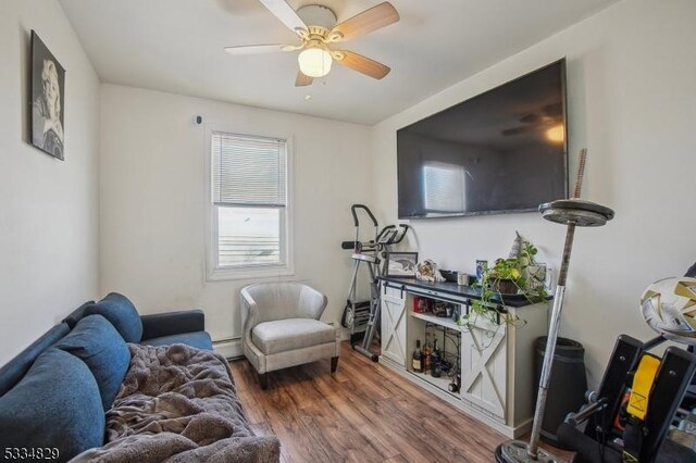 living room featuring hardwood / wood-style flooring, a baseboard radiator, and ceiling fan