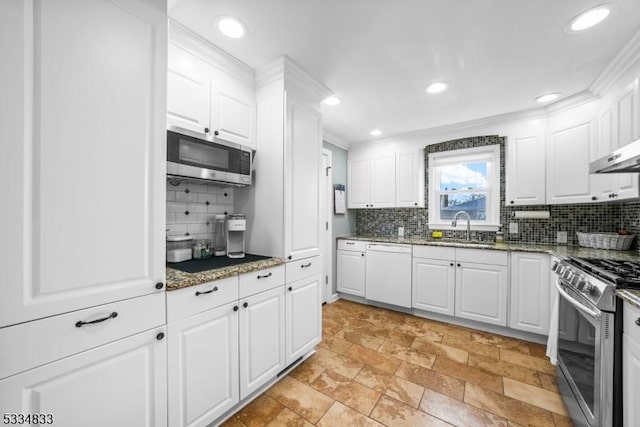 kitchen with white cabinetry, appliances with stainless steel finishes, sink, and dark stone counters