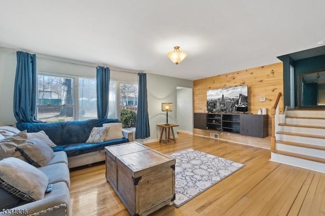 living room featuring wooden walls and light wood-type flooring