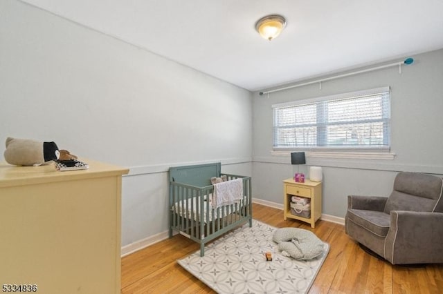 bedroom featuring a crib and hardwood / wood-style floors