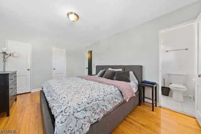 bedroom featuring ensuite bathroom and light hardwood / wood-style floors