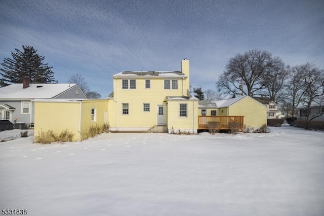 snow covered house featuring a wooden deck