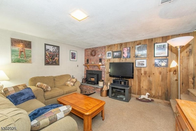 living room featuring carpet floors, a wood stove, and wood walls